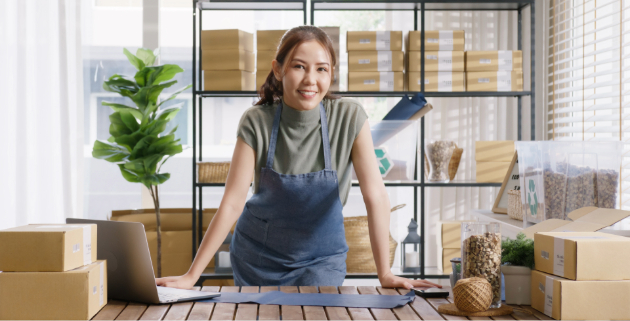 woman in apron packaging boxes