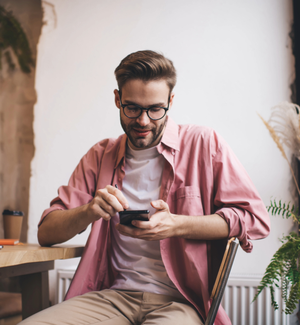 man in pink shirt on cellphone