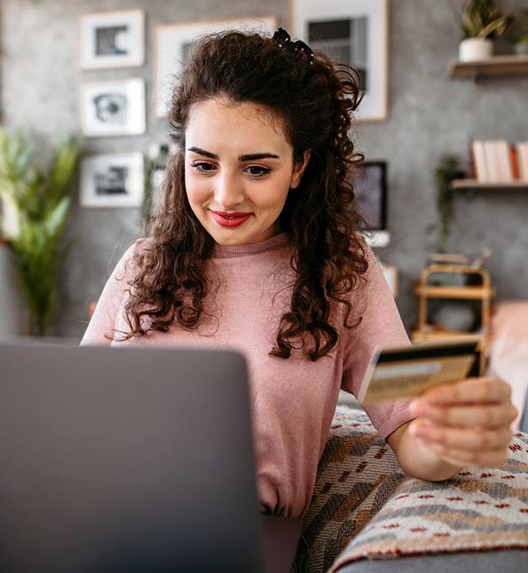 Woman using a credit card on her laptop at home