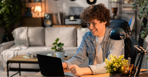 yound man in apartment looking at laptop