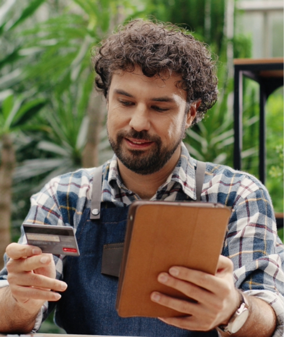 man holding tablet looking at credit card