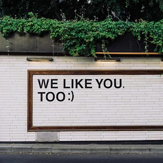 We like you too sign painted on a brick wall